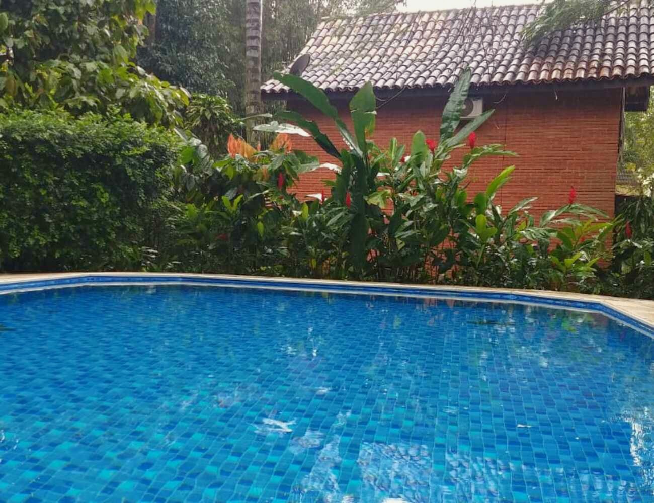 Piscina do condomínio com a casa ao fundo