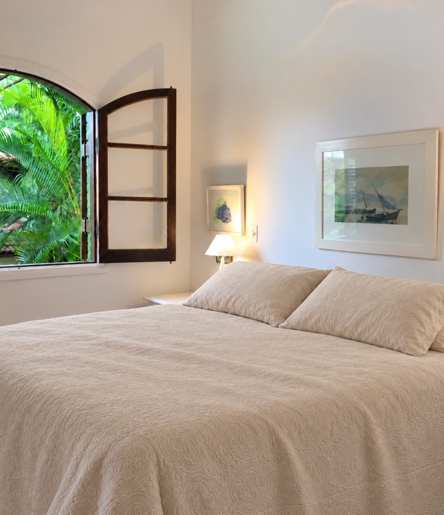 Suíte master com cama de casal e janela aberta para o jardim